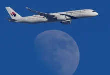 A Malaysian Airlines Airbus A350-900 passenger aircraft is seen flying in front of the moon, over London, Britain. (Reuters)