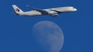 A Malaysian Airlines Airbus A350-900 passenger aircraft is seen flying in front of the moon, over London, Britain. (Reuters)